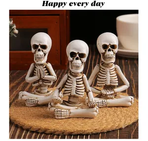 Close-up of three handcrafted resin skeleton figurines in meditation yoga poses on a jute mat.