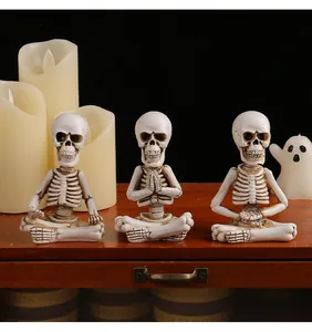 Close-up view of three resin meditation skeleton figurines for gothic Halloween decor