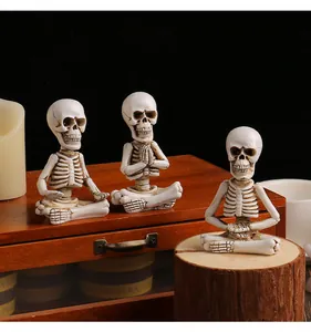 Three meditating skeleton resin figurines on wood stump for Halloween decor.