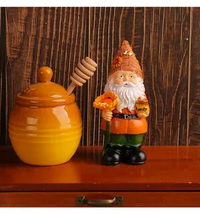 Close-up of garden gnome figurine holding sunflower and honey pot in garden setting.