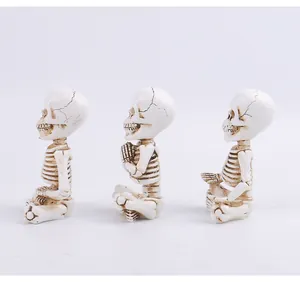 Side view of three meditating skeleton figurines for Halloween desktop decoration