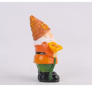 Side view of a decorative resin garden gnome figurine holding a yellow sunflower