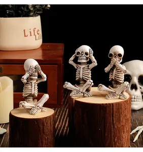 Detail view of three wise skeleton figurines on rustic wood logs for Halloween home decor