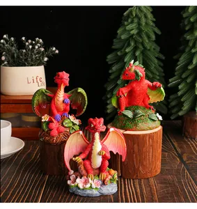 Detailed view of three cute red resin dragon figurines in a garden-themed setting