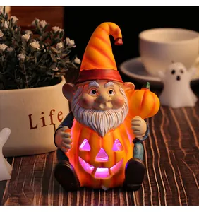 Vista dettagliata della calda luce interna di uno gnomo di Halloween in resina con una zucca