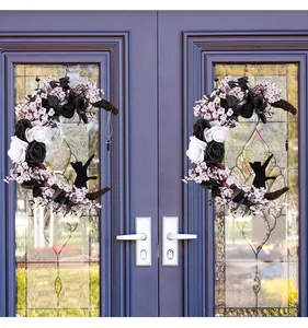 Detail of Halloween crescent moon cat wreath with black and white roses on a door.