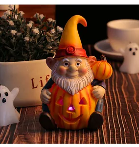 Statuetta gnomo di Halloween luminosa con zucca in una calda atmosfera festiva