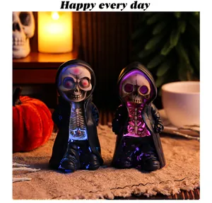 Close-up detail of Halloween skeleton resin figurines with glowing LED light effects.