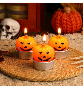 Detailed view of three lit Jack-o'-lantern pumpkin tea light candles for Halloween decor