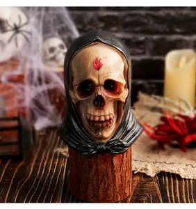 Vista dettagliata di una statuina di teschio in resina con cappuccio per Halloween