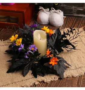 Detailaufnahme eines Halloween-Kerzenkranzes mit schwarzen Blättern und Blumen