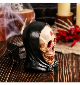 Dettaglio ravvicinato di un teschio in resina con cappuccio nero per decori di Halloween