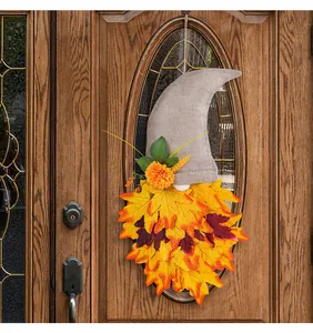 Couronne décorative de chapeau de gnome d'automne avec feuilles d'érable sur une porte