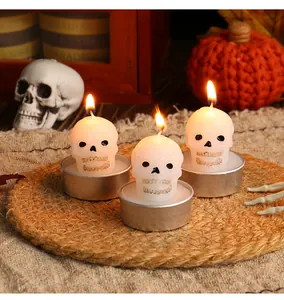 Detail of lit skull-shaped tea light candles for Halloween party decor