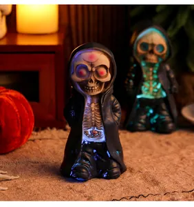 Close-up detail view of glowing Halloween skeleton figurines in resin with black hoodies
