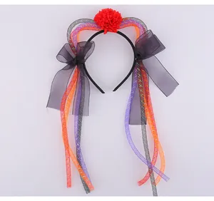 Dettaglio di cerchietto di Halloween in rete con nastri colorati e fiore rosso