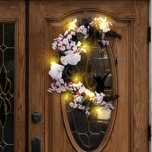 Spooky Halloween crescent moon wreath featuring black and white roses with warm LED lights