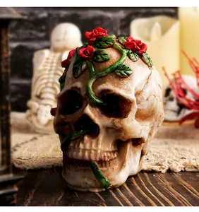 Détail d'une figurine de crâne d'Halloween en résine avec roses rouges et vignes.