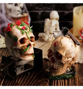 Vue détaillée de crânes d'Halloween en résine avec motifs de roses et de hache