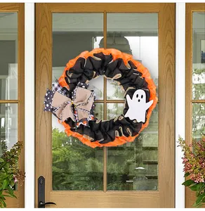 Halloween wreath featuring a ghost and burlap bow hanging on a glass front door decor