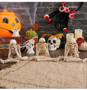 Detailed view of three resin skeleton figurines in hear, see, speak no evil poses