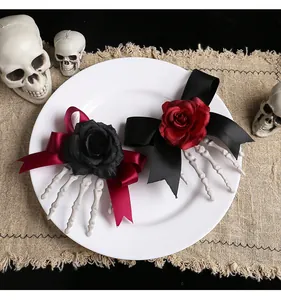 Pair of Halloween skeleton hand hair clips with red and black roses and satin bows