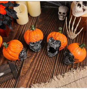 Detailed view of Halloween skull ornaments with orange pumpkin hats on wooden table
