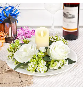 Detailed view of an elegant artificial white rose wreath with a central LED candle