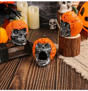 Detail view of handmade resin Halloween skull ornaments with vibrant orange pumpkin hats.