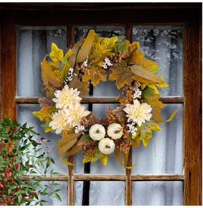 Detailansicht eines Herbstkranzes mit Ahornblättern, weißen Kürbissen und Dahlien.
