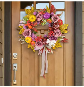 Close-up of harvest wreath with roses and pumpkins on a rustic wooden farmhouse door