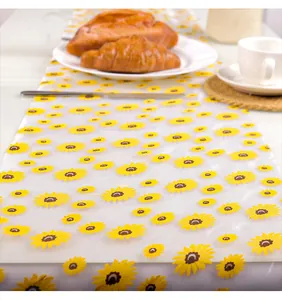 Vue rapprochée de l'imprimé tournesol sur un chemin de table en maille blanche pour fête