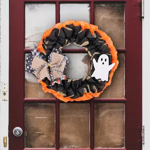 Festive Halloween wreath with orange mesh, burlap bow and a cute white ghost for door decor.