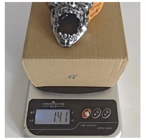 Detailed shot of a Halloween skull resin ornament weighing approximately 141g on a scale
