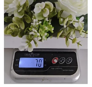 Detail of white rose floral wreath weighing 70g on a precision kitchen scale