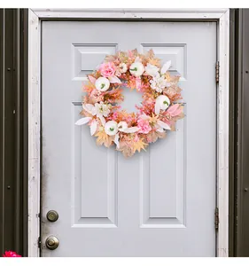 Detailansicht eines herbstlichen Kranzes mit rosa Blumen und weißen Kürbissen