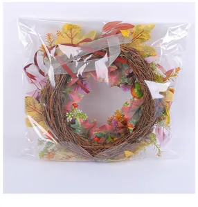 Autumn harvest decorative wreath with colorful maple leaves in transparent plastic packaging