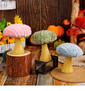 Vista dettagliata di tre ornamenti a fungo in peluche colorati con steli in gesso decor