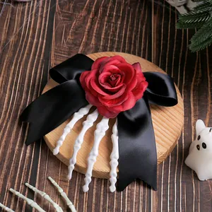 Halloween skeleton hand hair clip with red rose and black satin bow on wood background