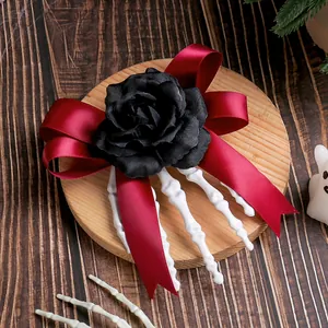 Halloween skeleton hand hair clip featuring a black artificial rose and burgundy satin bow