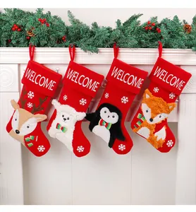 Set aus vier roten Weihnachtsstrümpfen mit festlichen Tierapplikationen am Kamin
