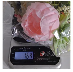 Close-up showing weight of pink artificial flower bouquet on digital scale