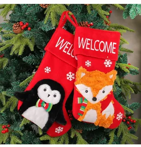 Detailansicht roter Nikolausstiefel mit 3D-Plüschfiguren von Pinguin und Fuchs im Baum