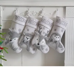 Set aus vier weiß-grauen Weihnachtssocken mit Tierfiguren und WELCOME-Stickerei.