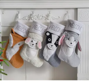 Nahaufnahme von vier süßen Weihnachtsstrümpfen mit Tiermotiven an einem weißen Kamin.