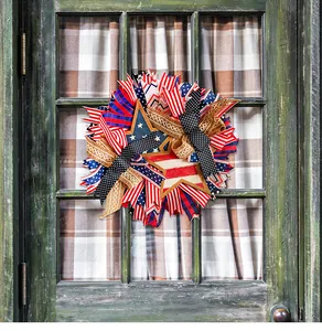 Detailed view of patriotic Independence Day wreath with red white blue ribbons on green door