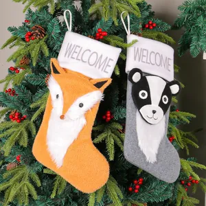 Set mit zwei dekorativen Weihnachtsstrümpfen mit Fuchs- und Dachsmotiv am Baum