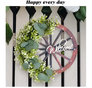 Gros plan d'une couronne de roue de wagon rustique avec verdure et signe Welcome