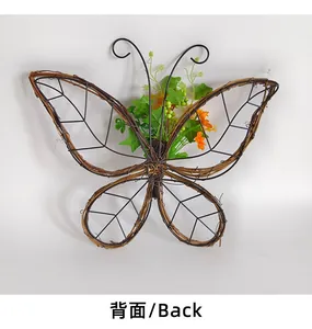 Vista posterior de corona de vid en forma de mariposa con flores para decoración de pared