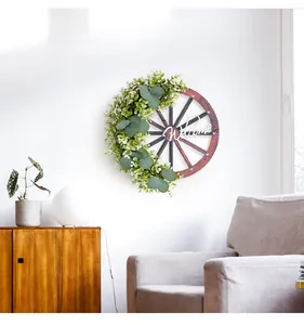 Gros plan d'une couronne de roue de chariot en bois avec verdure et signe Welcome déco.